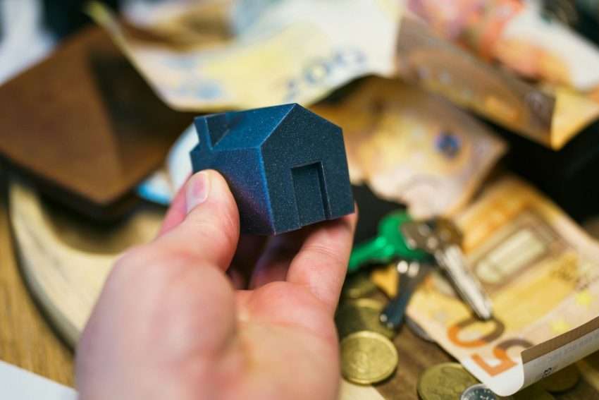Buying a house with money, keys, and coins.